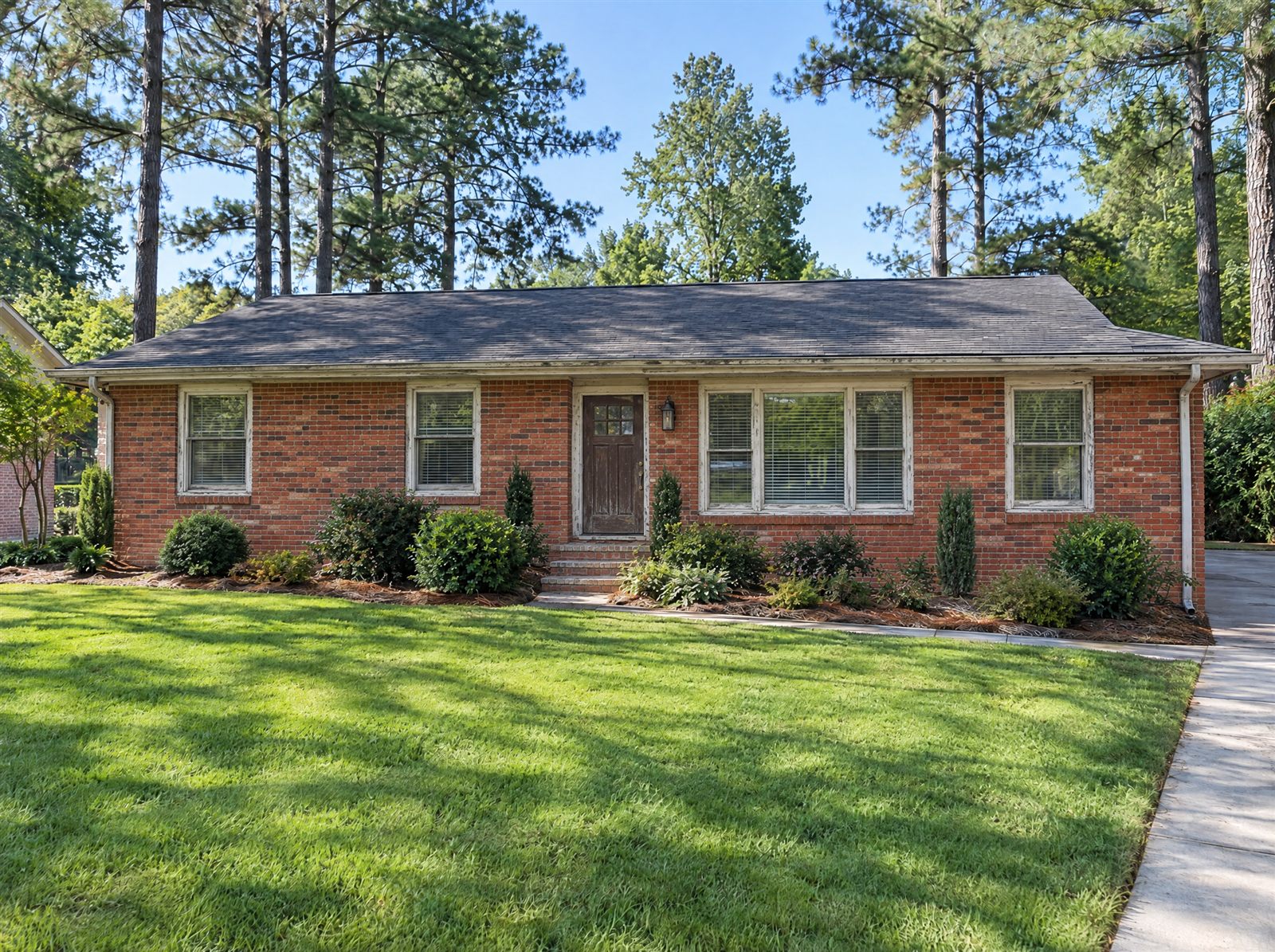 Brick ranch house with orange-red brick and worn trim
