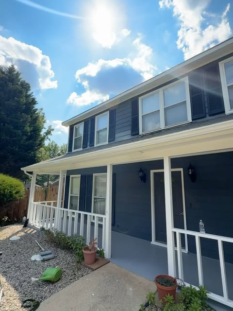 Navy blue house with a white porch
