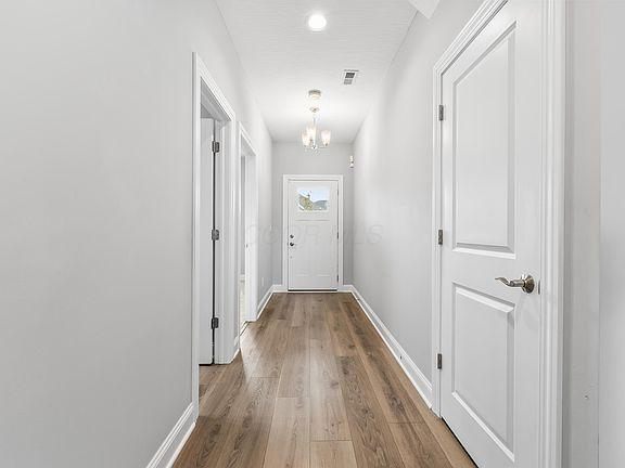 Hallway with light gray walls and white doors